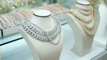 Colliers de perles et de chaînes présentés sur des bustes blancs en vitrine