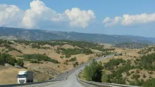 Camion de transport sur une route sinueuse au milieu de collines