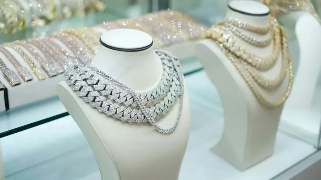 Colliers de perles et de chaînes présentés sur des bustes blancs en vitrine