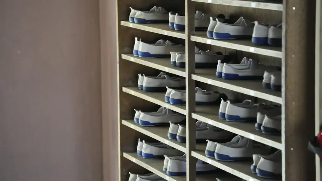 Étagères métalliques remplies de paires de baskets blanches rangées en série