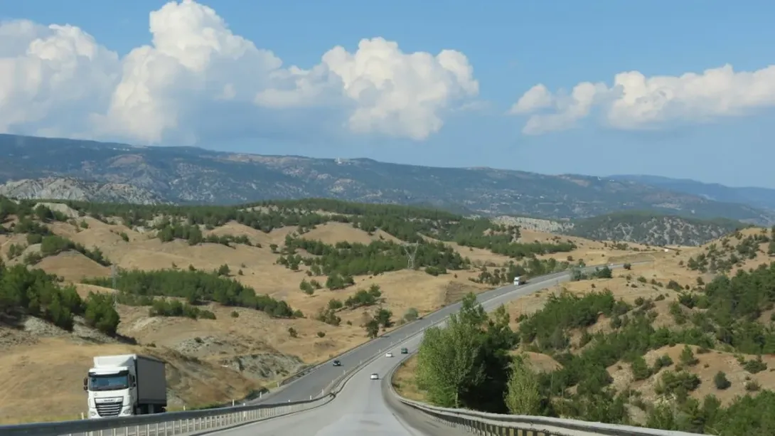 Camion de transport sur une route sinueuse au milieu de collines